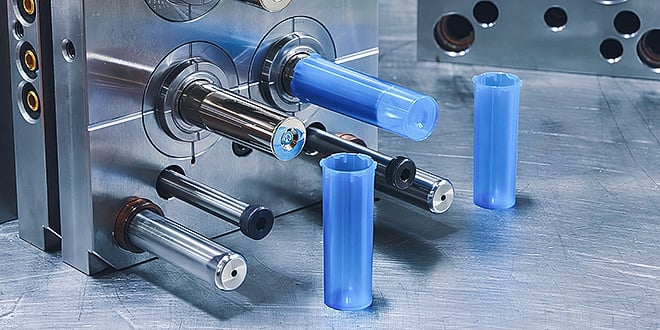 Close-up of a multi-cavity injection mould producing blue plastic tubes, illustrating efficient high-volume manufacturing for medical devices.