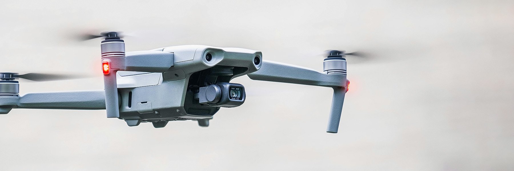 A surveillance drone soars gracefully through a clear, cloudless sky.