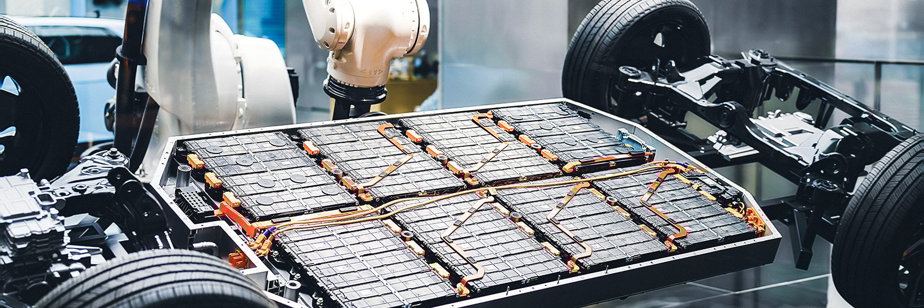The manufacturing arm mounts EV batteries onto the vehicle frame.