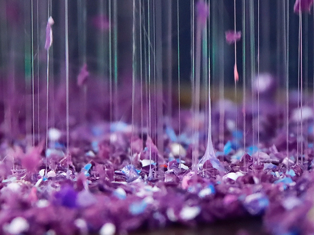 Purple plastic granules melt and transform into fine threads.