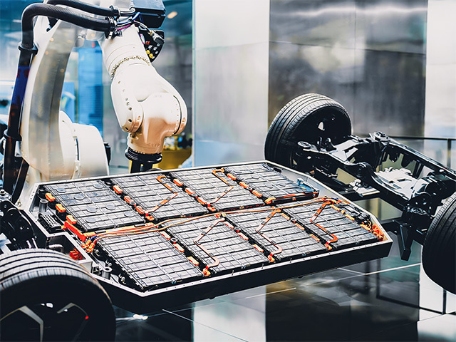 The manufacturing arm mounts EV batteries onto the vehicle frame.